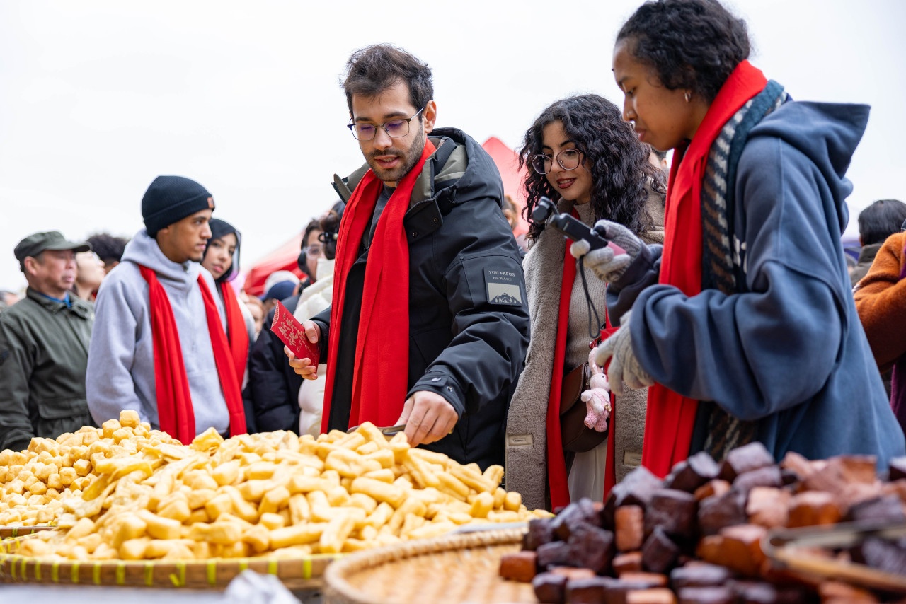 九游娱乐平台：留学生沉浸式感受老街集市零距离触摸地道中国年(图1)